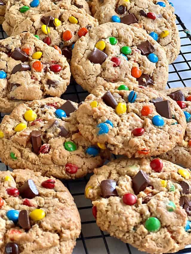 Freshly baked monster cookies on a wire cooking rack