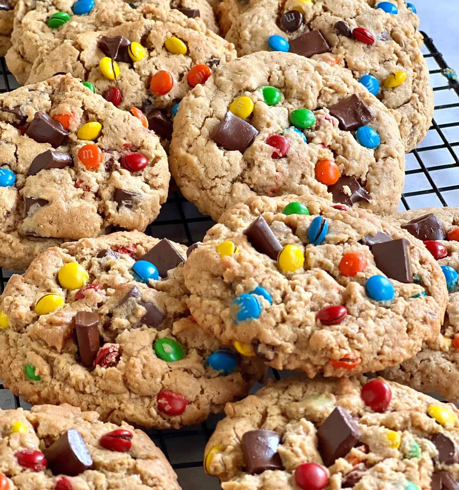 Freshly baked monster cookies on a wire cooking rack