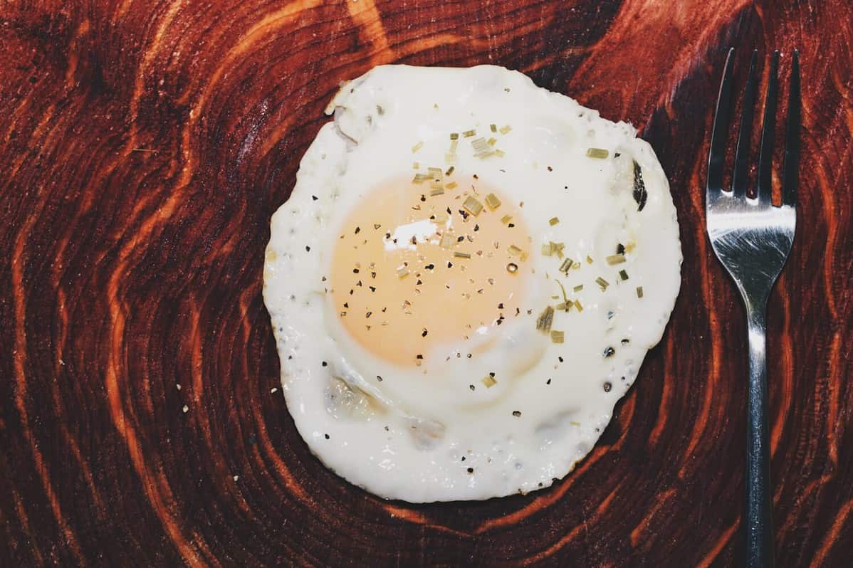 One over easy egg on wooden surface