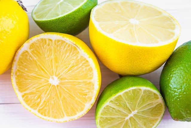 lemons and limes on a wooden background.