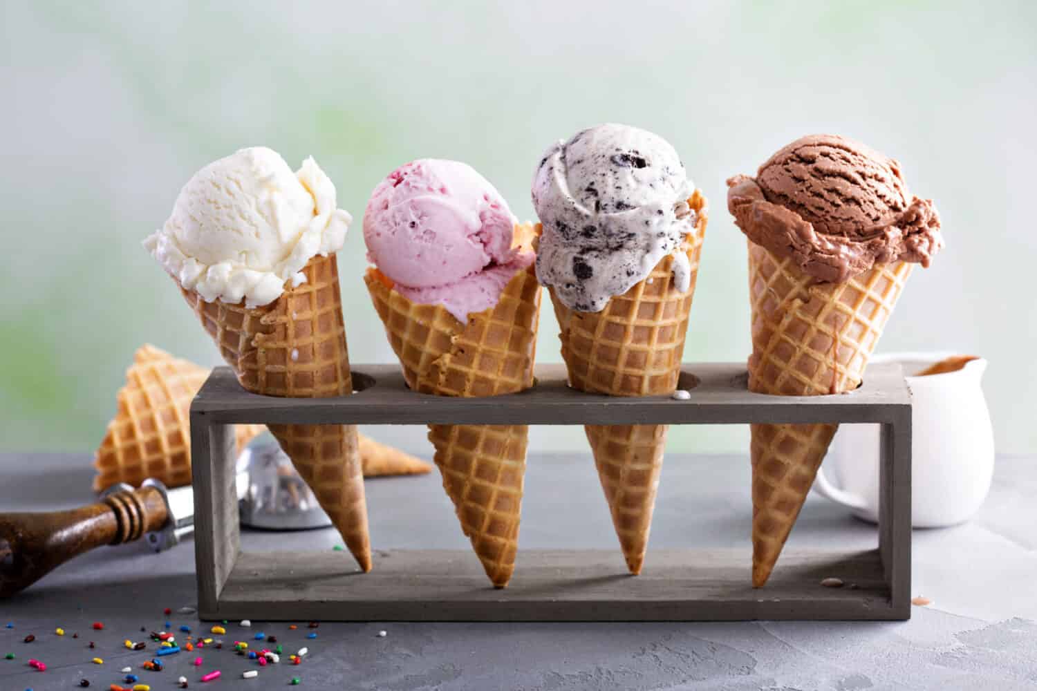 Variety of ice cream scoops in cones with chocolate, vanilla and strawberry