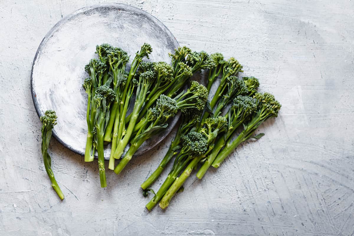 Broccolini, broccoli florets green vegetable broccolini grows baby broccoli vegan food grey table overhead