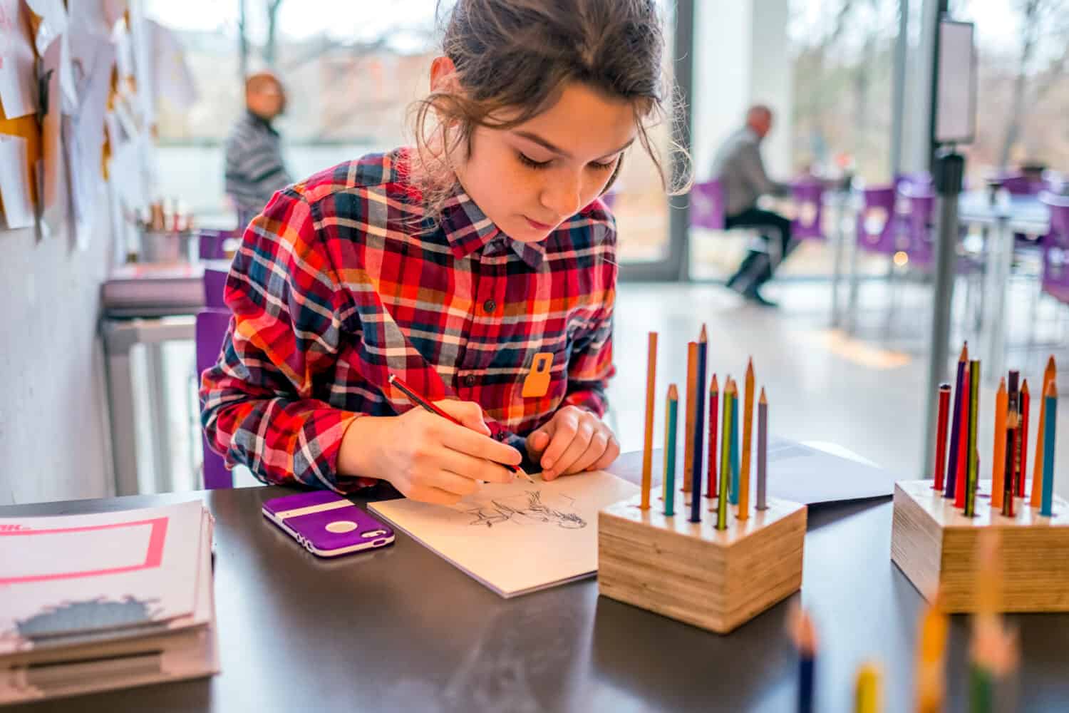 Cute schoolgirl drawing with pencils. A concept of teaching drawing, master classes in museums. Children's creativity, education. Danish national gallery. Educational programs.