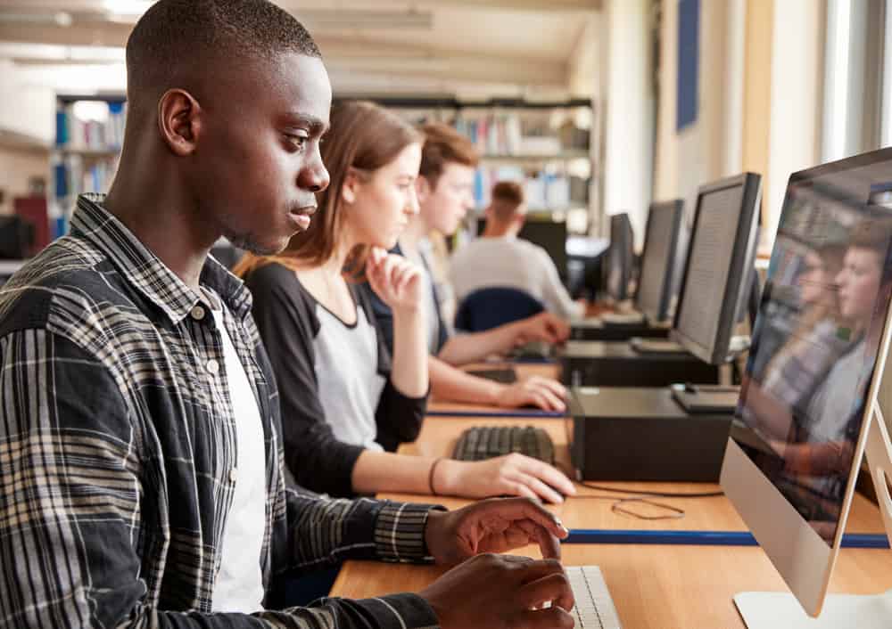 Group Of Students Using Computers In College Library