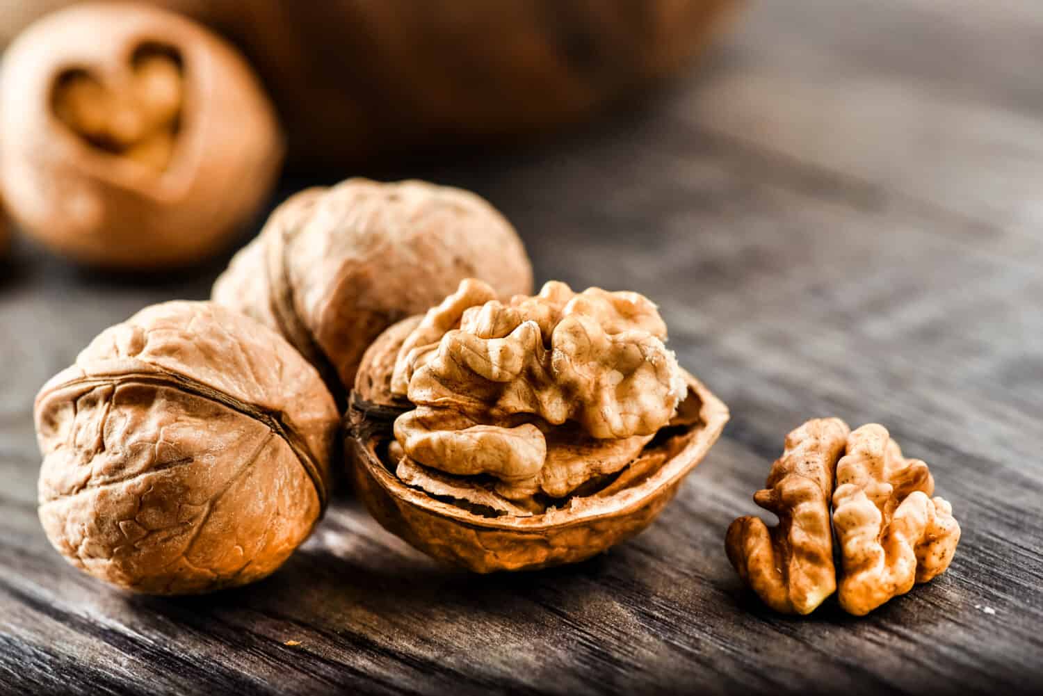 Walnuts on dark vintage table, Walnuts kernels in wooden bowl. Walnut healthy food