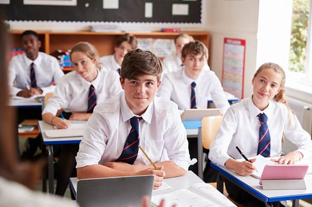 Students Listening To Female Teacher In Classroom