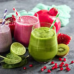 Colorful smoothie, healthy detox vitamin diet or vegan food concept, fresh vitamins, breakfast drink with spinach, pomegranate, figs and blueberries