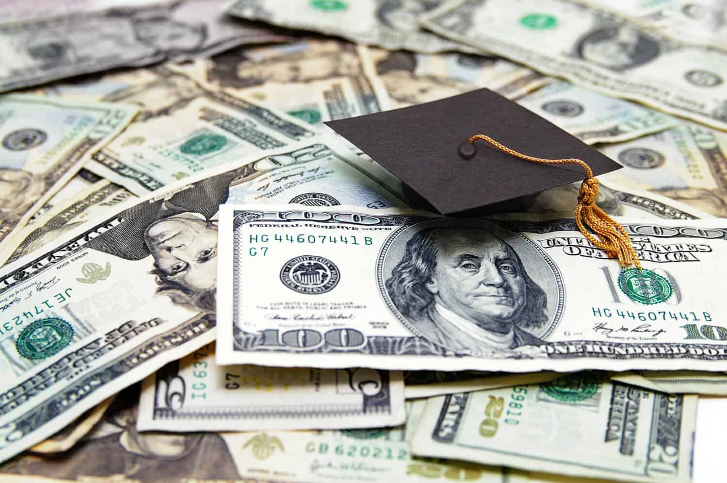 mini graduation cap on US money -- education costs
