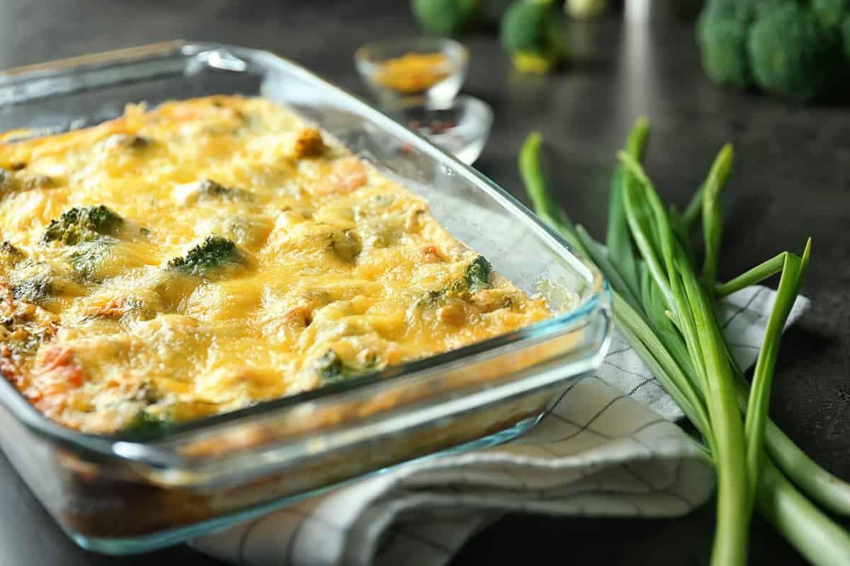 Glass baking dish with tasty broccoli casserole on table. Fresh from oven