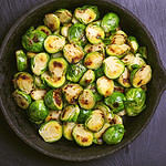 Vegetarian cuisine. Homemade Brussels Sprouts roasted with olive oil on black slate background. Copyspace, top view, flatlay.