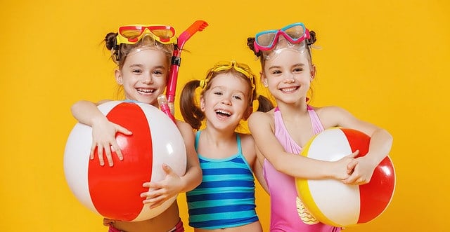 funny funny happy children jumping in swimsuit and swimming glasses jumping on colored background