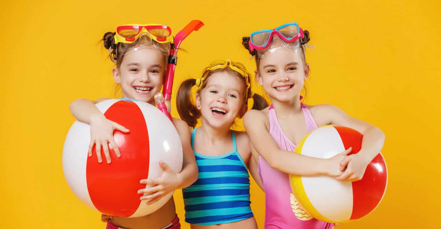 funny funny happy children jumping in swimsuit and swimming glasses jumping on colored background