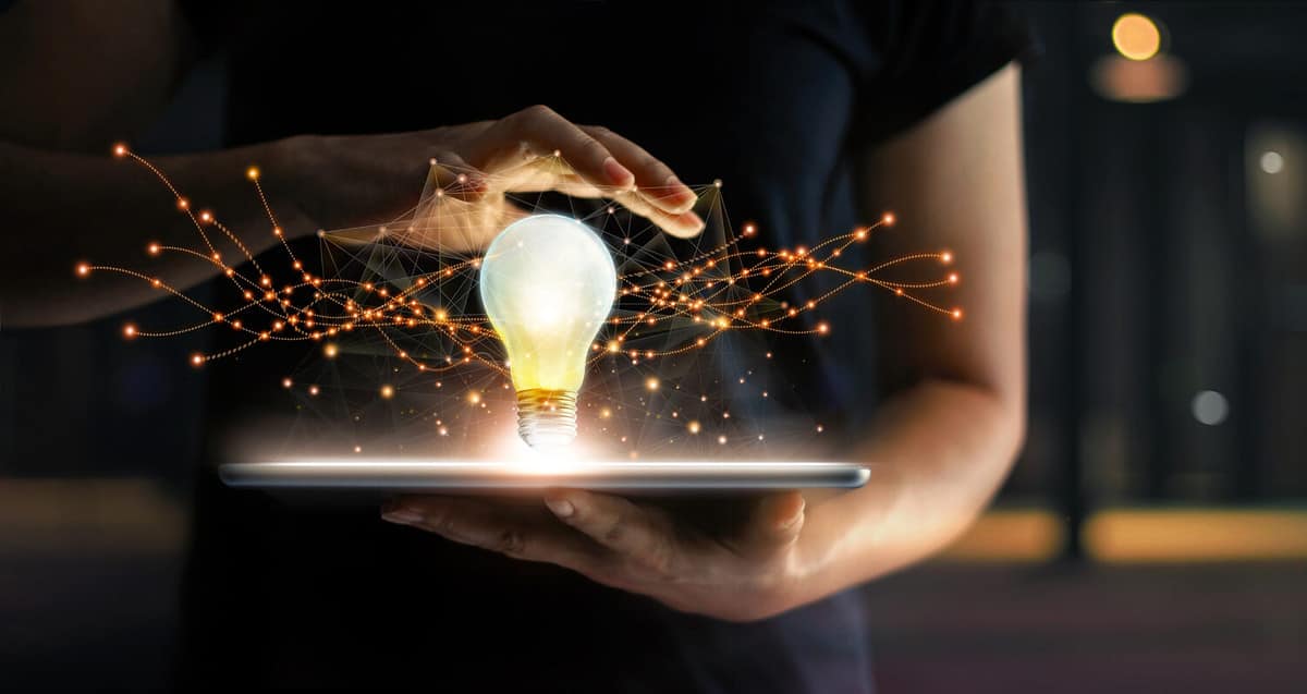 Abstract. Innovation. Hands holding tablet with light bulb future technologies and network connection on virtual interface background, innovative technology in science and communication concept