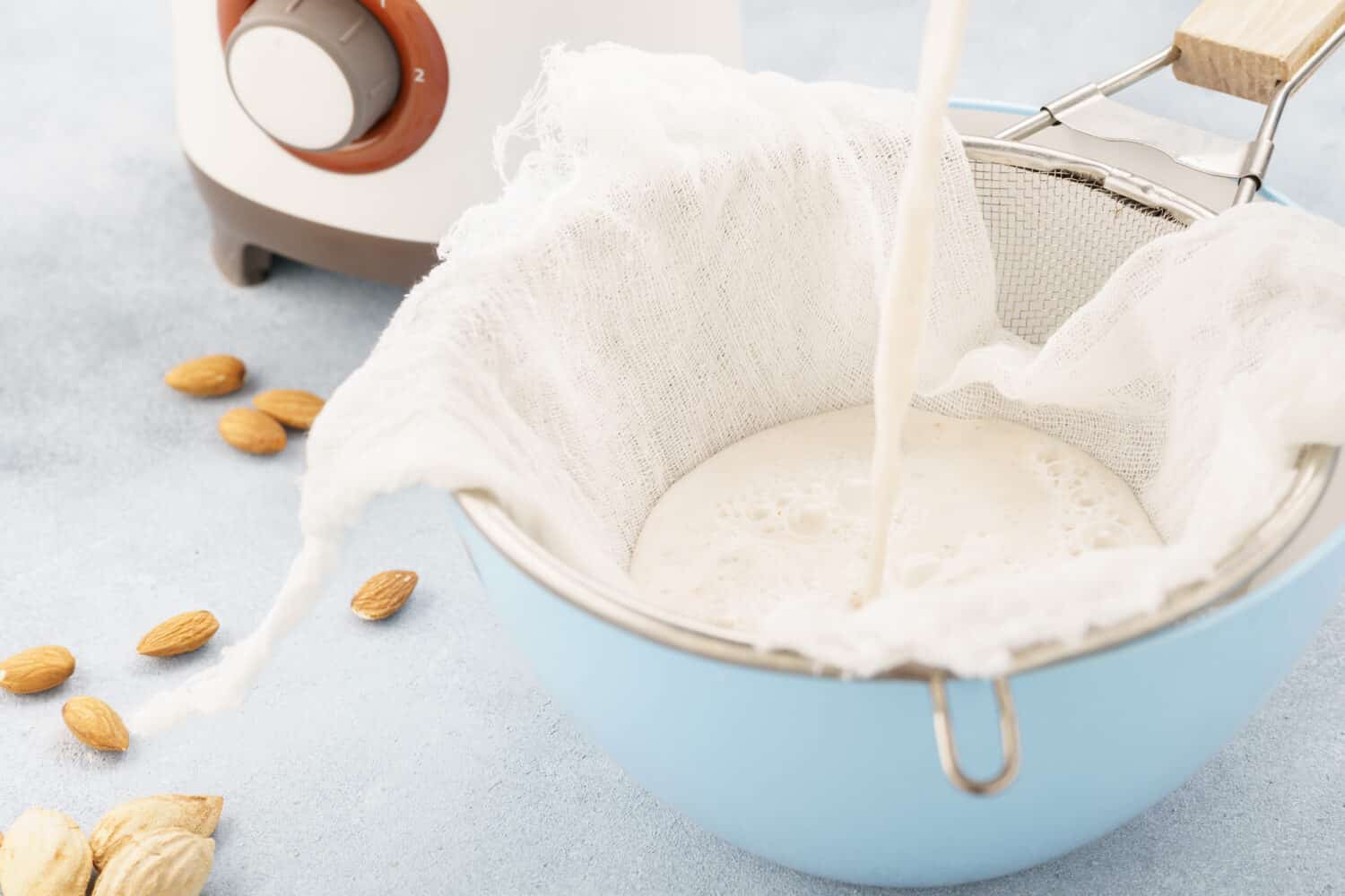 Homemade nut milk making process. Pouring milk into cloth. Step by step recipe.