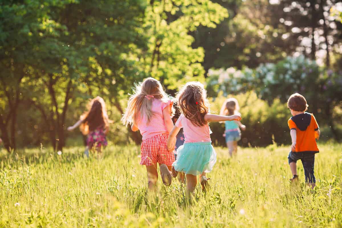 Children running in the grass playing.