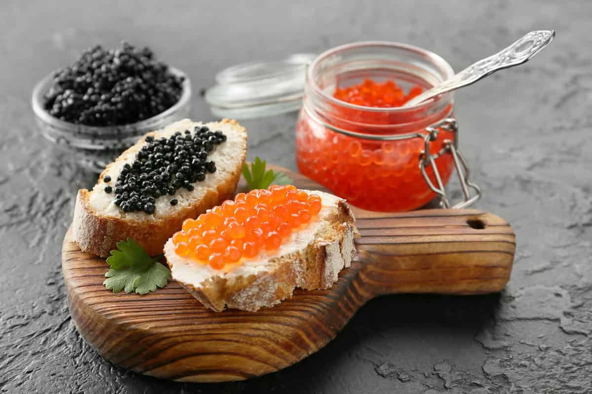 Sandwiches with delicious caviar on dark background