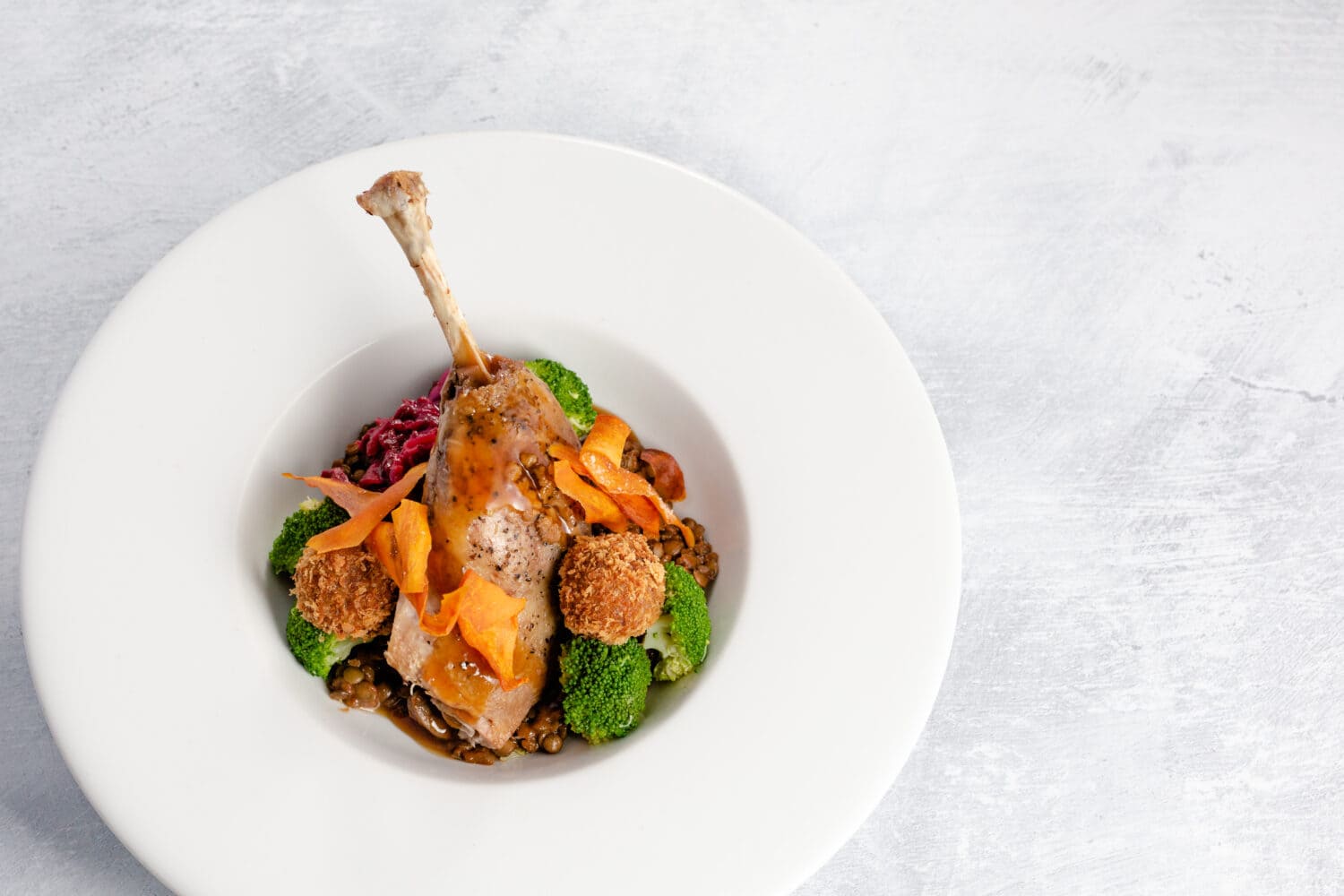 Slow cooked duck leg – duck and sloe gin bon bon, braised red cabbage, broccoli and a rich lentil cassoulet