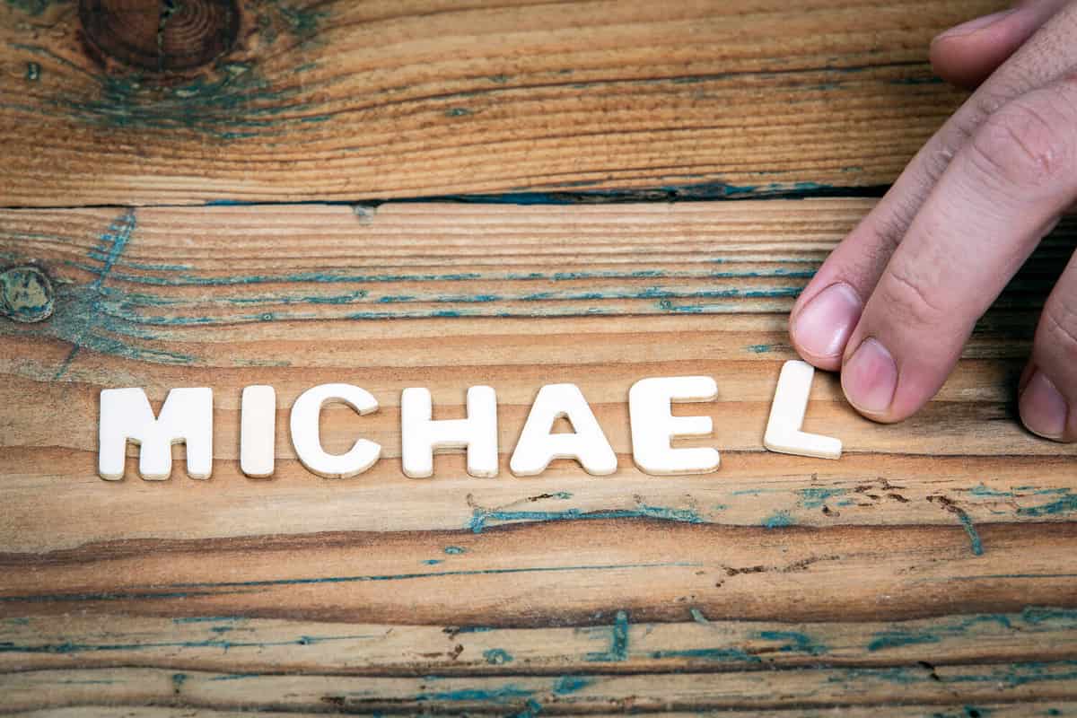 MICHAEL. Name of men and boys. Birthday concept. White letters of the alphabet on a wooden background.