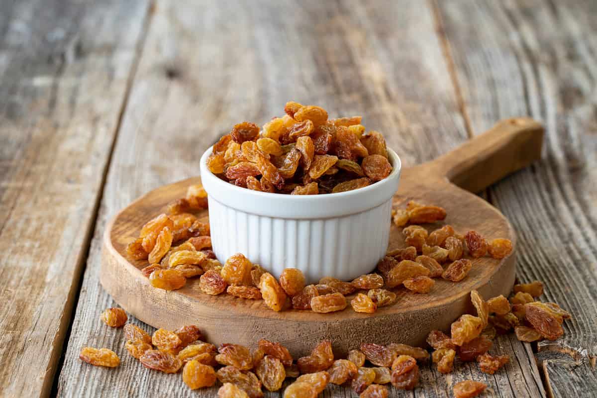 Dry raisins. Dry raisins nuts on wood floor. Bulk raisins grains. Raisins on a ceramic plate