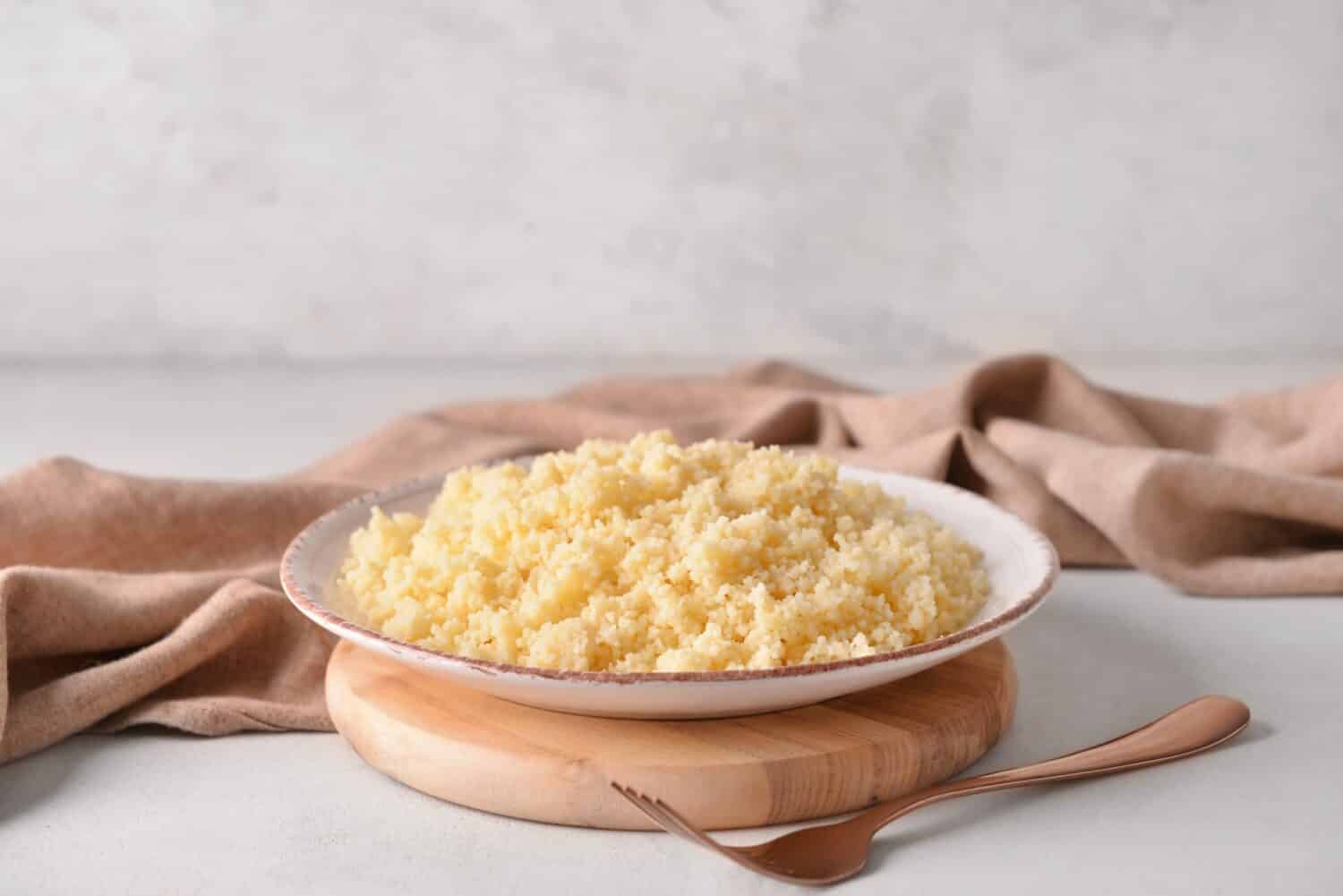 Plate with tasty couscous on table