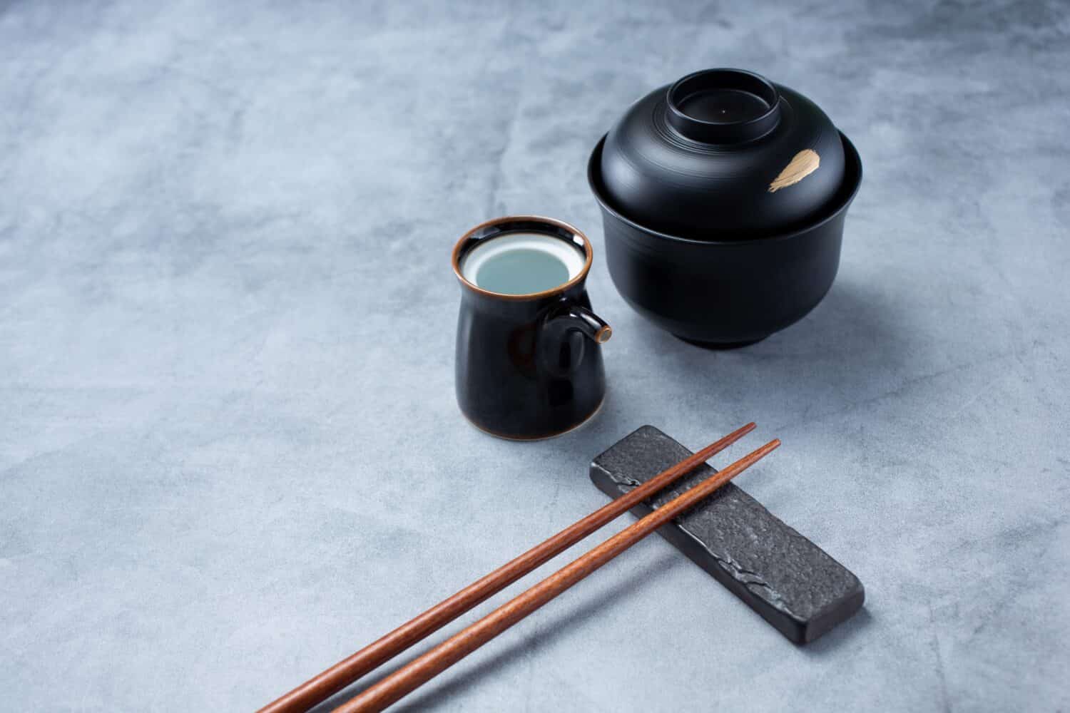 A view of a Japanese restaurant place setting, featuring chopsticks and soy sauce dishware.
