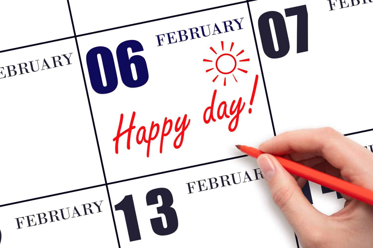 6th day of February. Hand writing the text HAPPY DAY and drawing the sun on the calendar date February 6. Save the date. Holiday. Motivation. Winter month, day of the year concept.