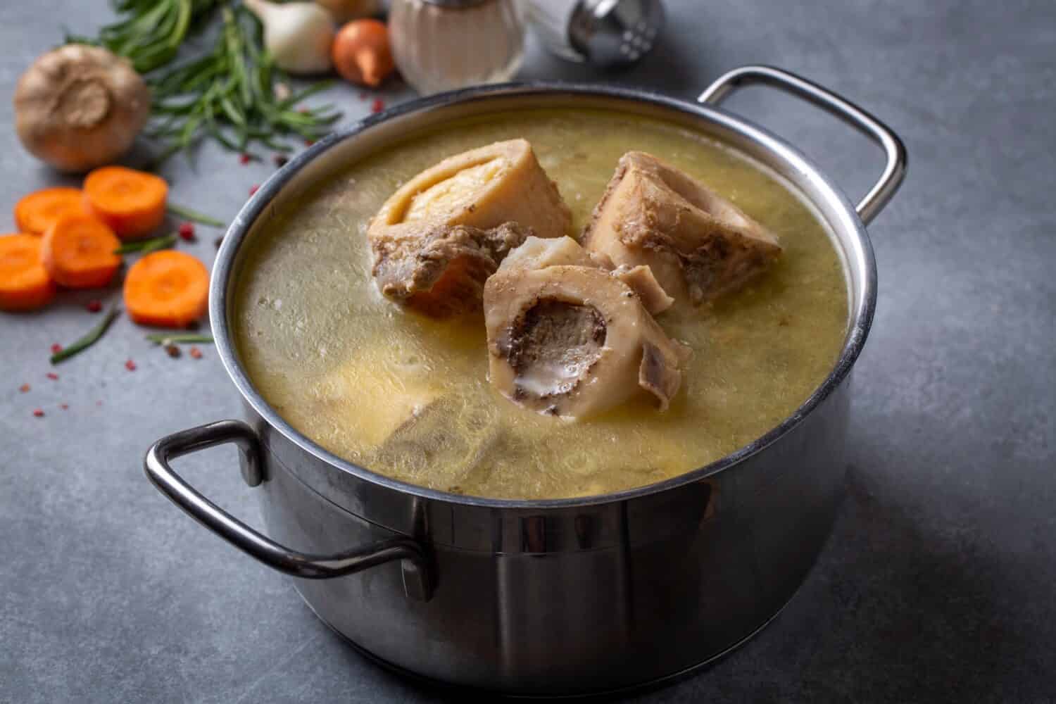 Boiled bone and broth. Homemade beef bone broth is cooked in a pot on. Bones contain collagen, which provides the body with amino acids, which are the building blocks of proteins.