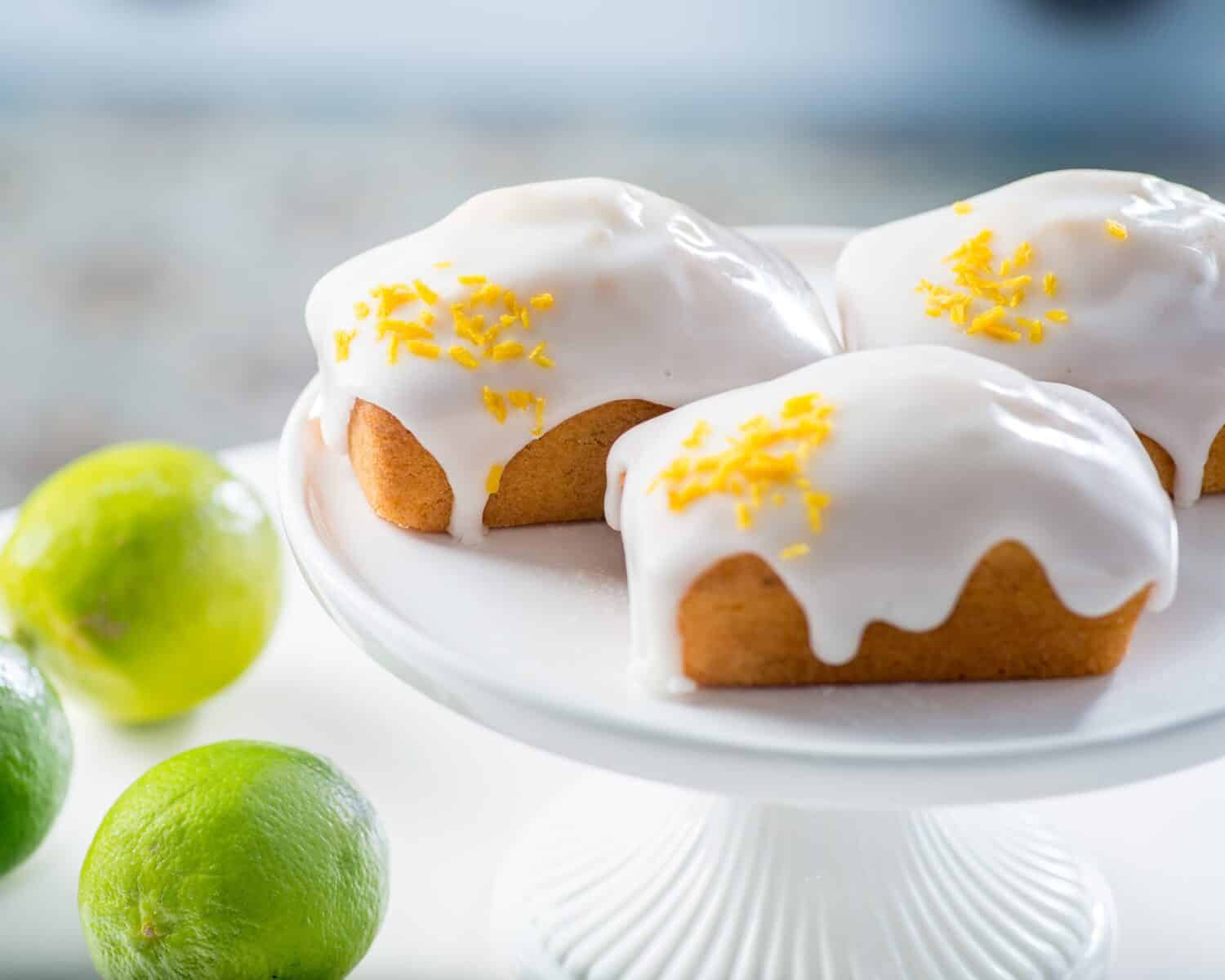 Rectangular muffins covered with white cream icing and sprinkled with lime zest