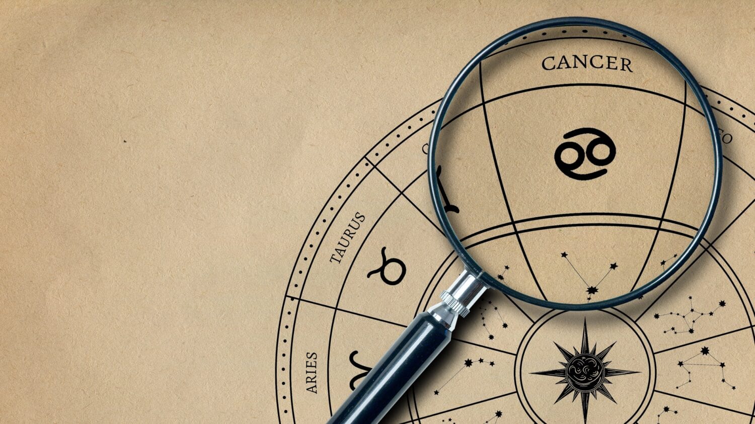 The imprint of the zodiac sign Cancer on old paper is enlarged with a lens