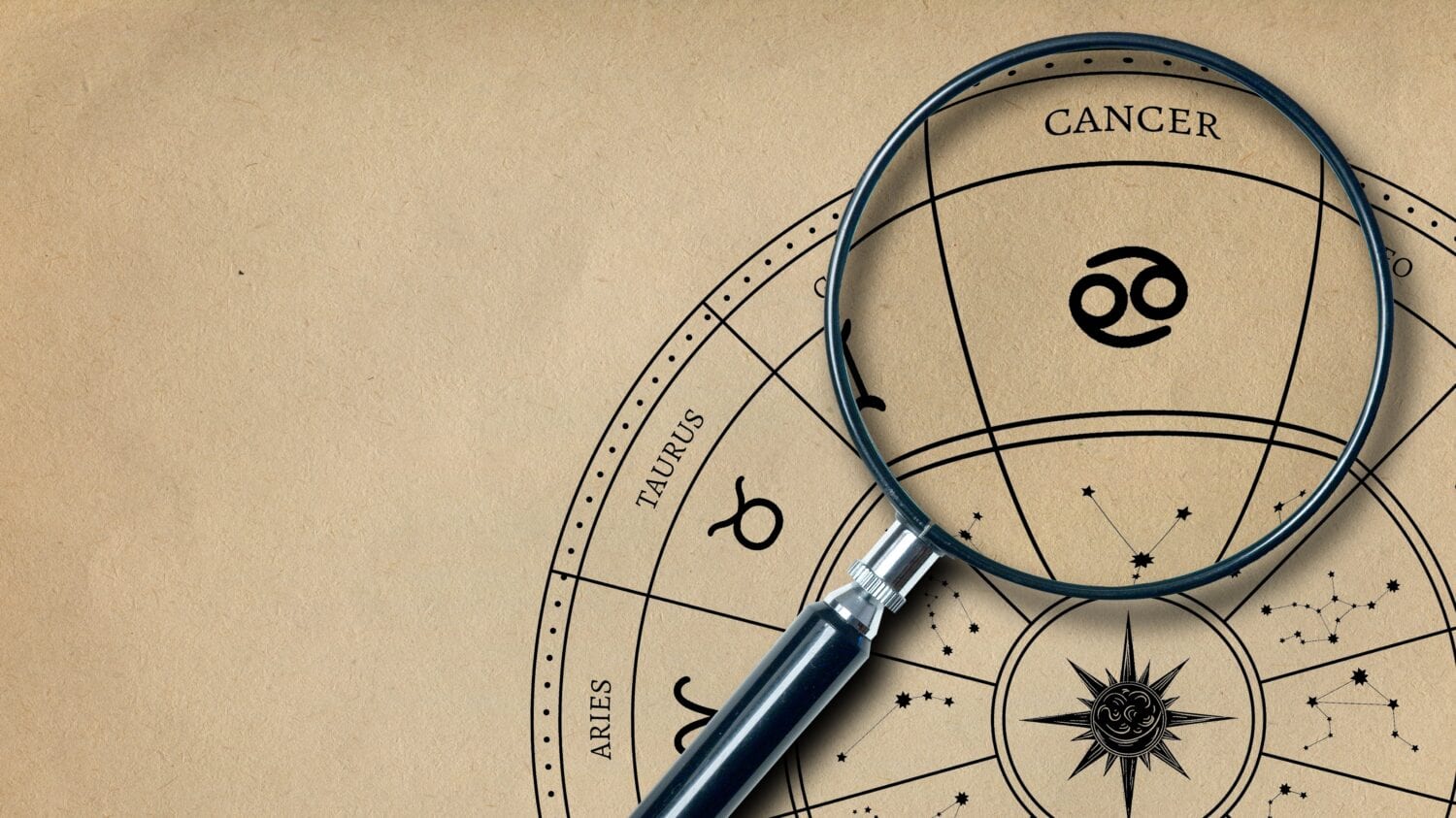 The imprint of the zodiac sign Cancer on old paper is enlarged with a lens