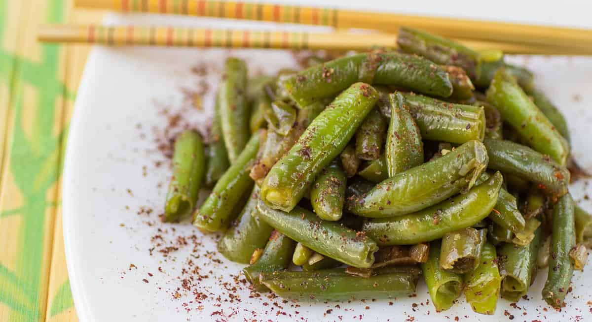 Green beans with garlic, onion and red pepper. Warm salad. The garnish. Dish Oriental cuisine. Selective focus