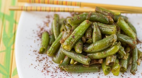 Green beans with garlic, onion and red pepper. Warm salad. The garnish. Dish Oriental cuisine. Selective focus