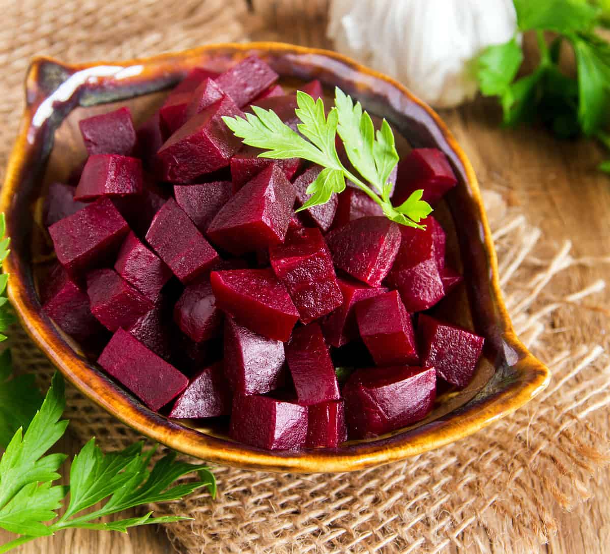 Beetroot (beet) chopped for salad in bowl over rustic wooden table