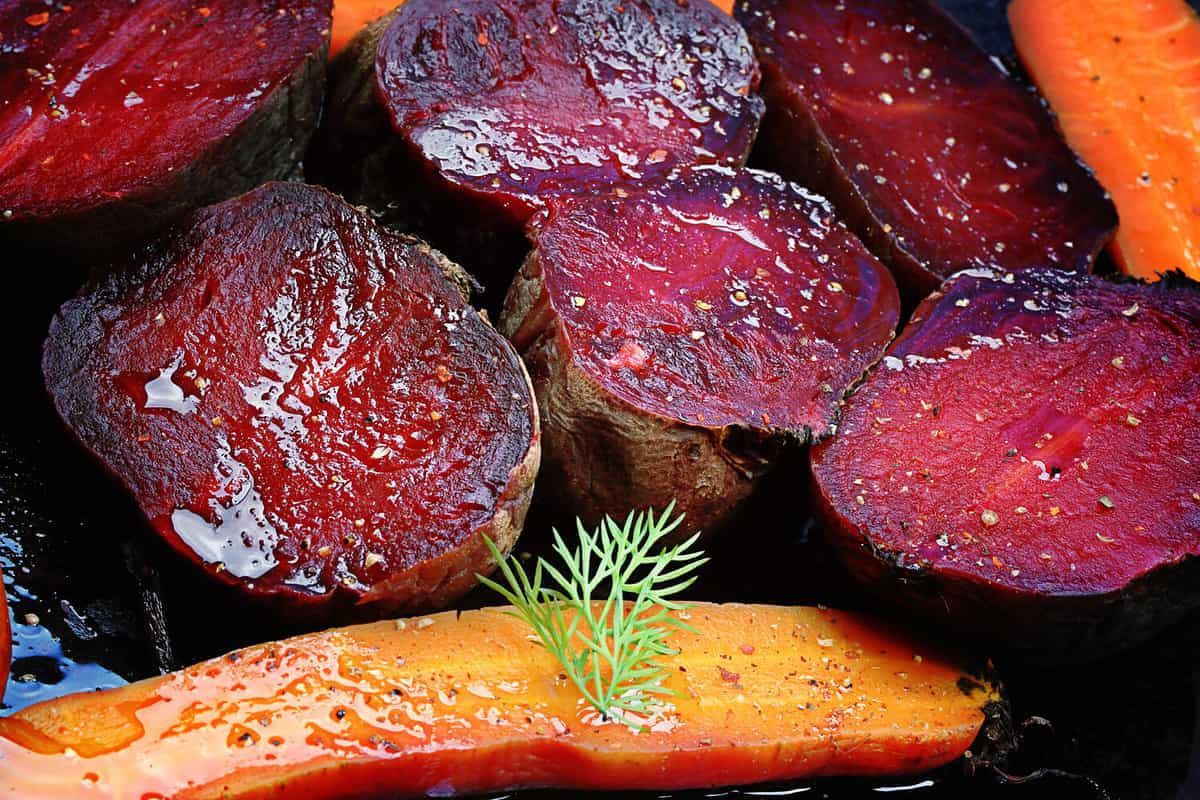 roasted vegetables beets carrots dark background selective focus toning rustic old style