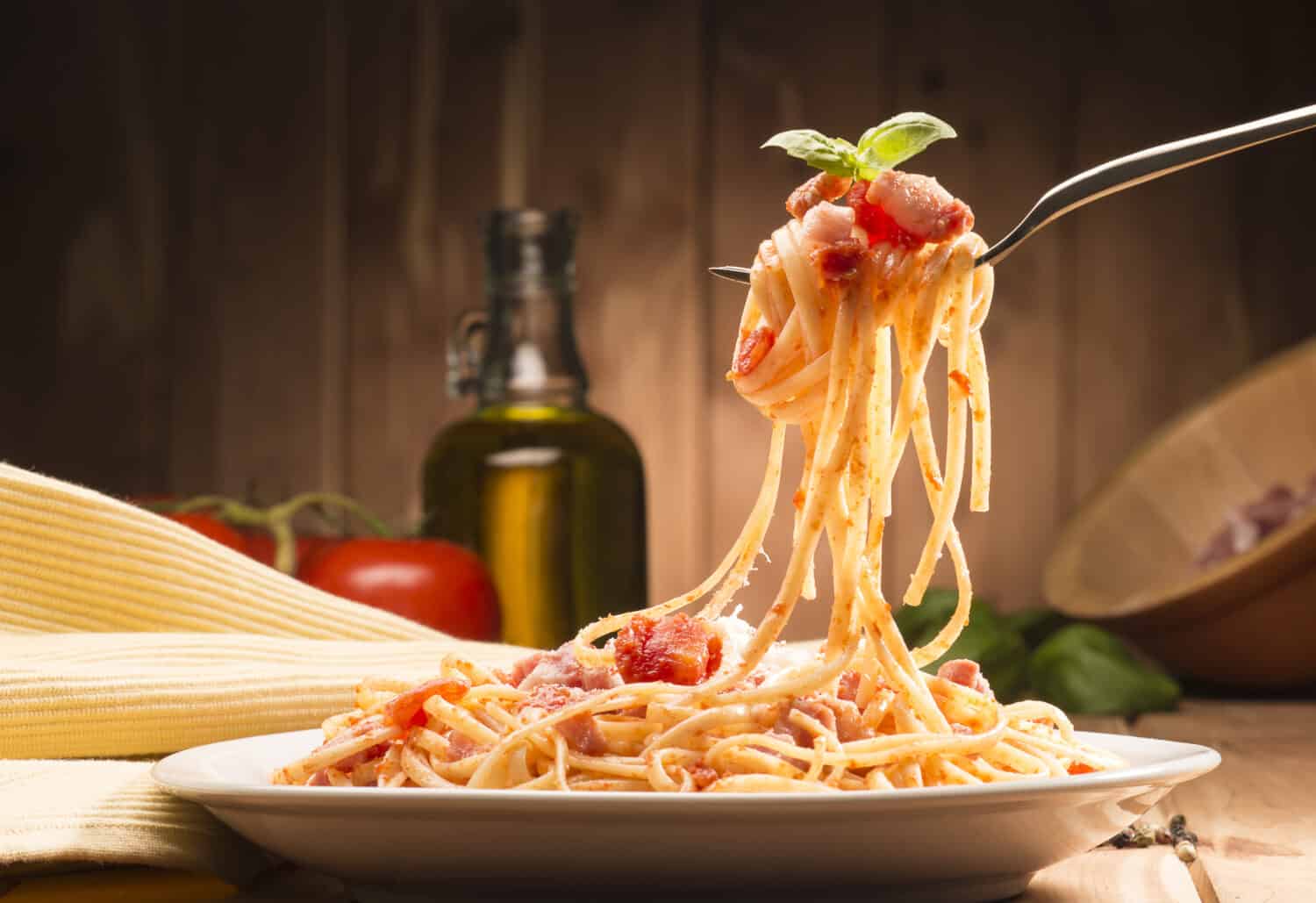 spaghetti with amatriciana sauce in the dish on the wooden table