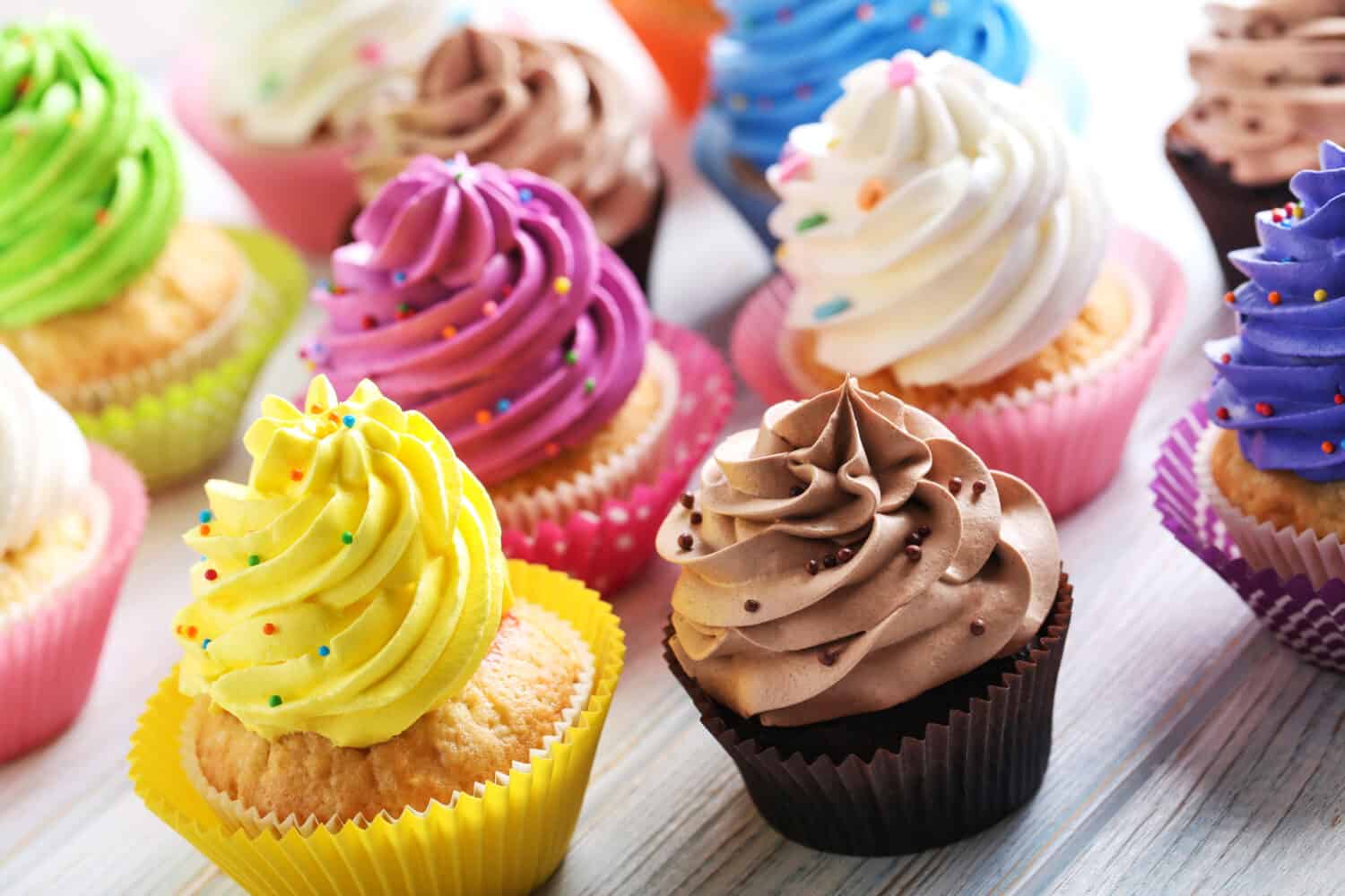 Tasty cupcakes on a white wooden table