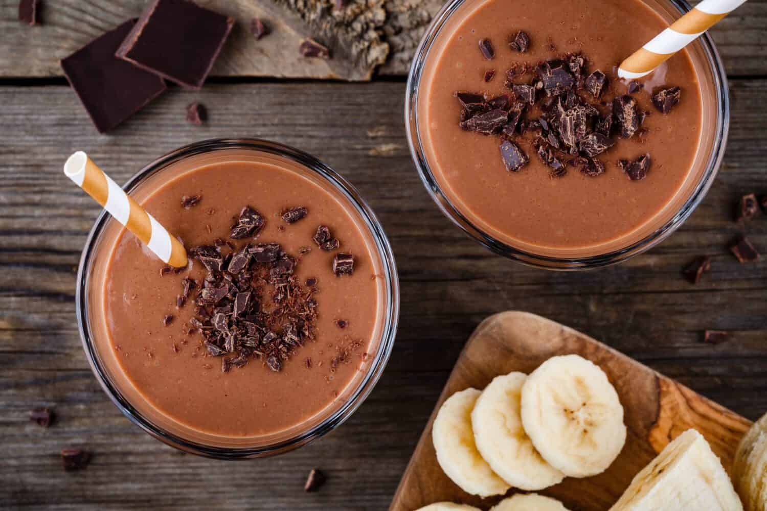 Chocolate smoothie with banana on rustic wooden background