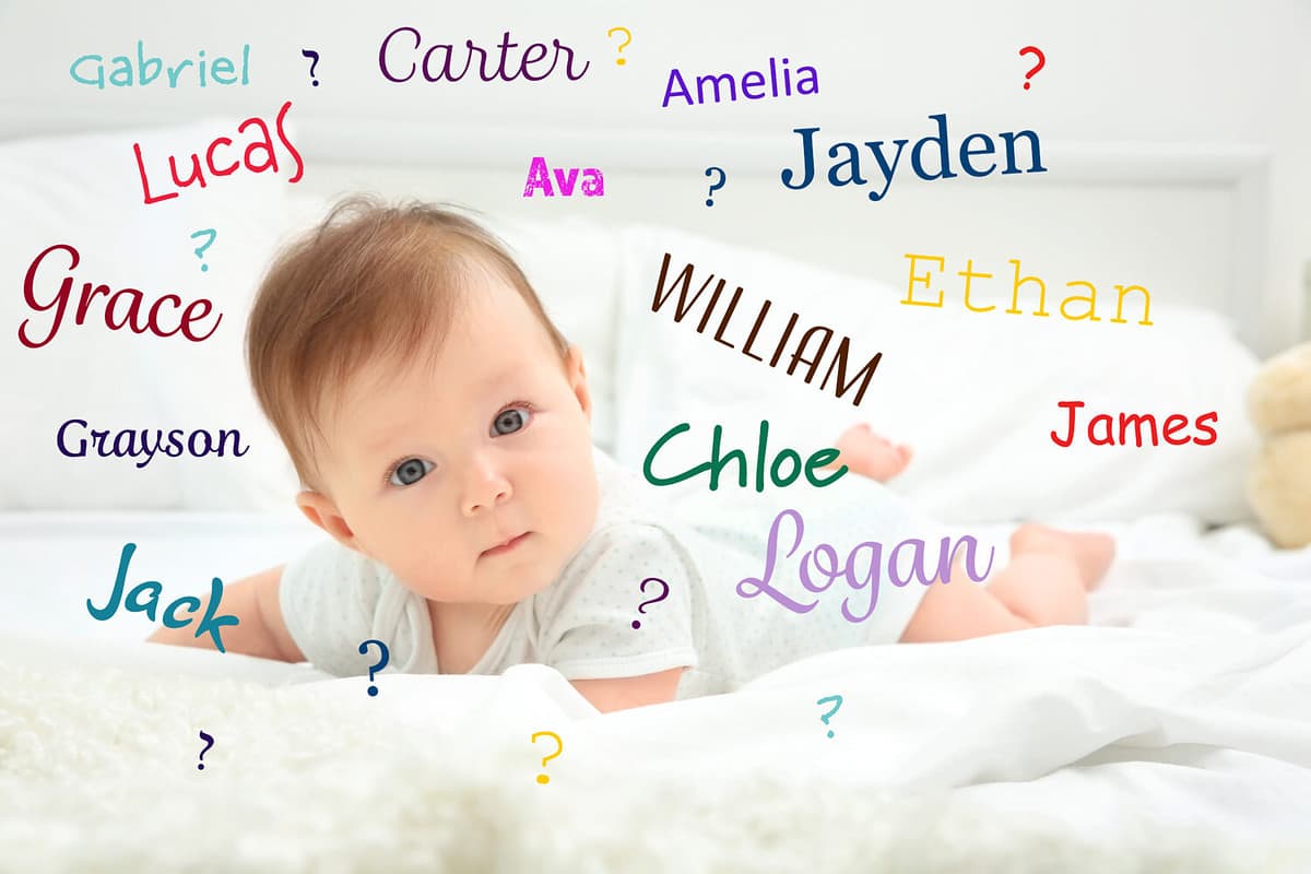 Cute baby lying on bed surrounded by names