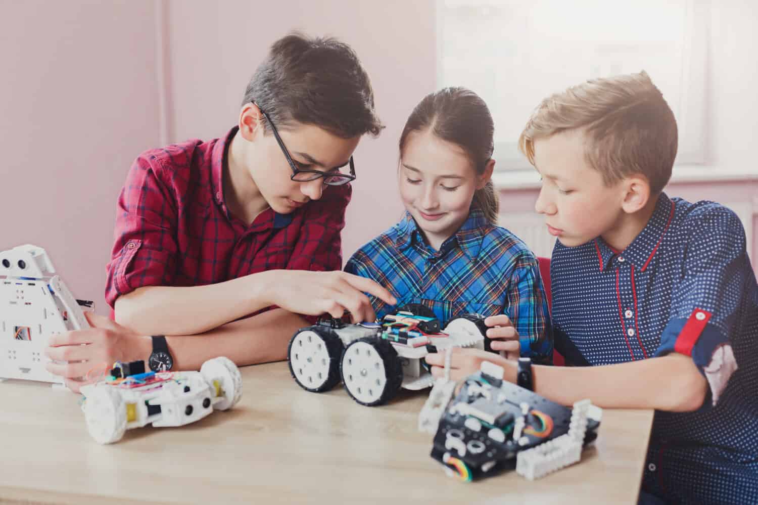 Children creating robots at school, stem education, copy space. Early development, diy, innovation, modern technology concept