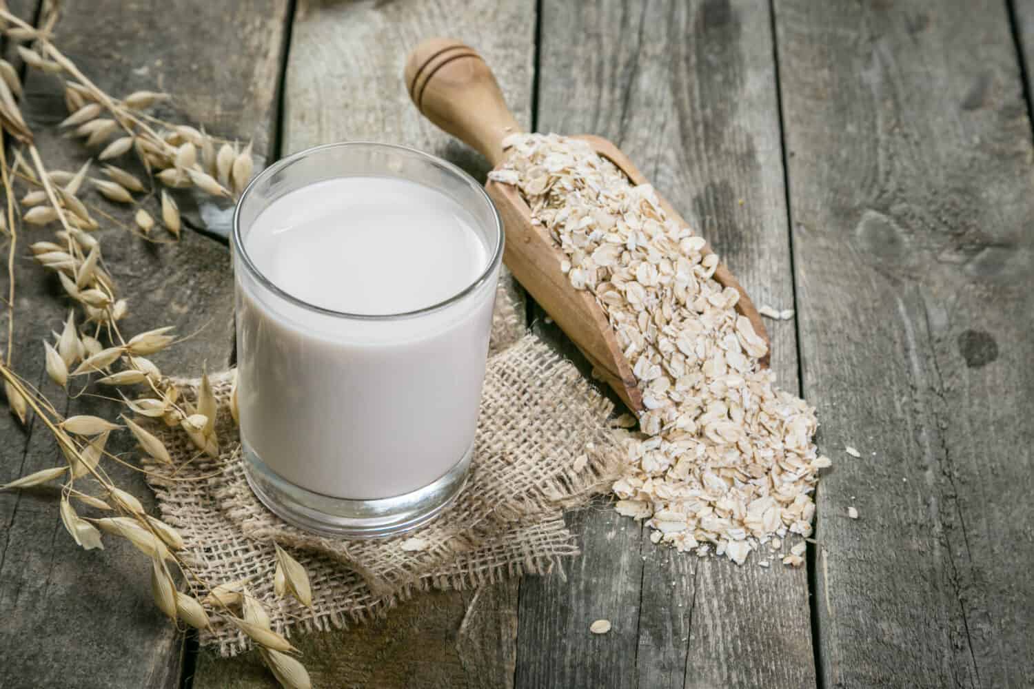 Oat milk alternative on rustic wood background, copy space