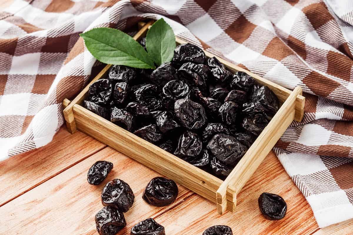 delicious dried prunes on a wooden rustic background.