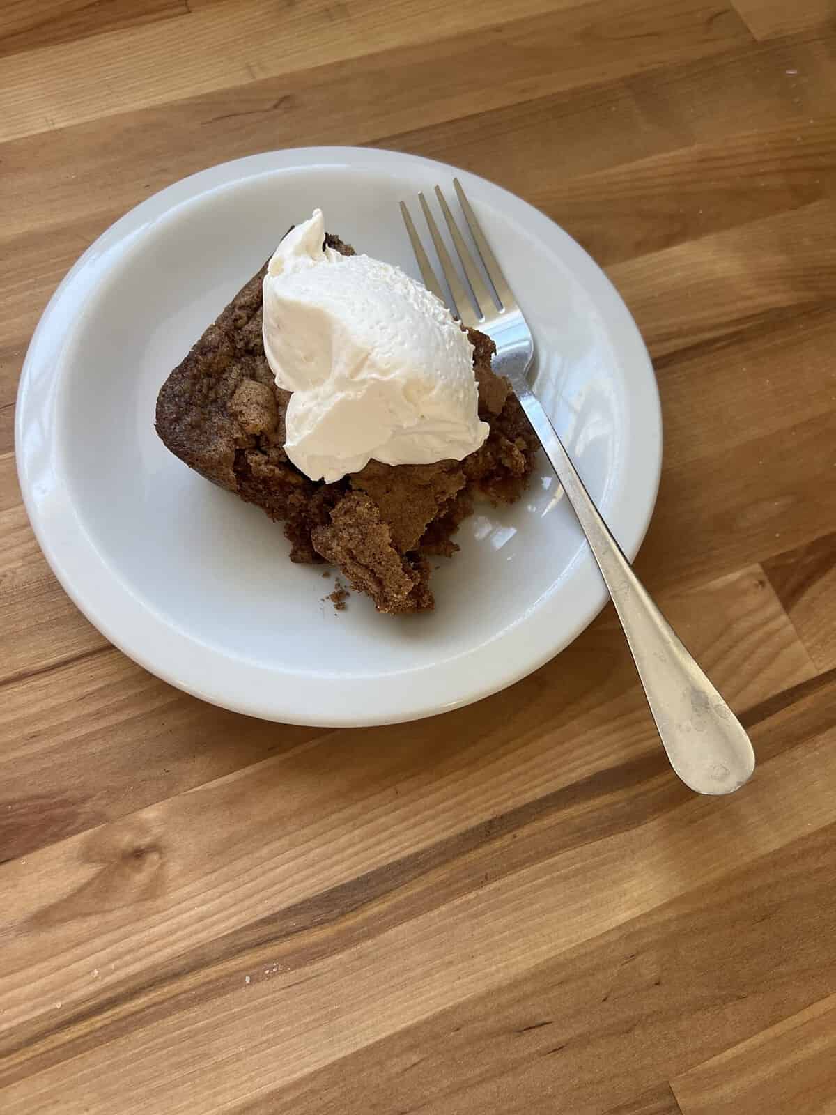 Slice of fresh apple dump cake with whipped cream