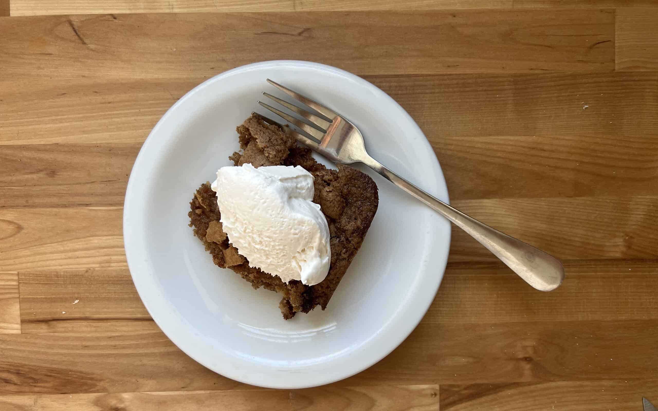 Slice of fresh apple dump cake with whipped cream