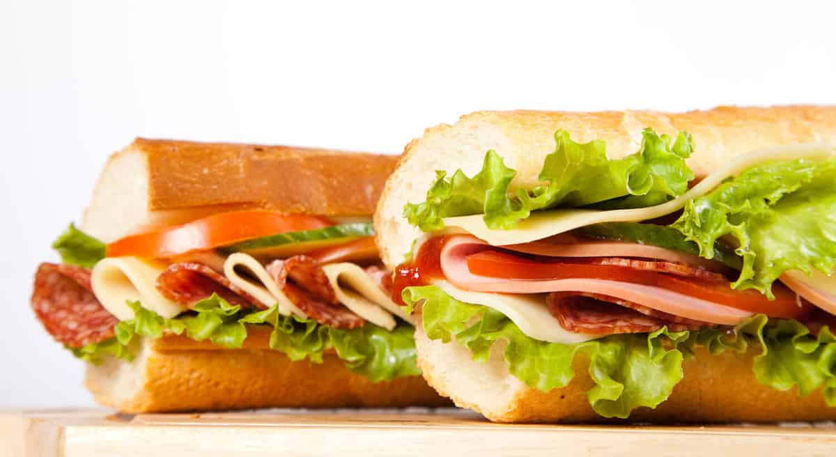 big sandwich with fresh vegetables on wooden board