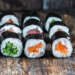 A selection of sushi rolls with salmon, tuna, cucumber and soy sauce dip.