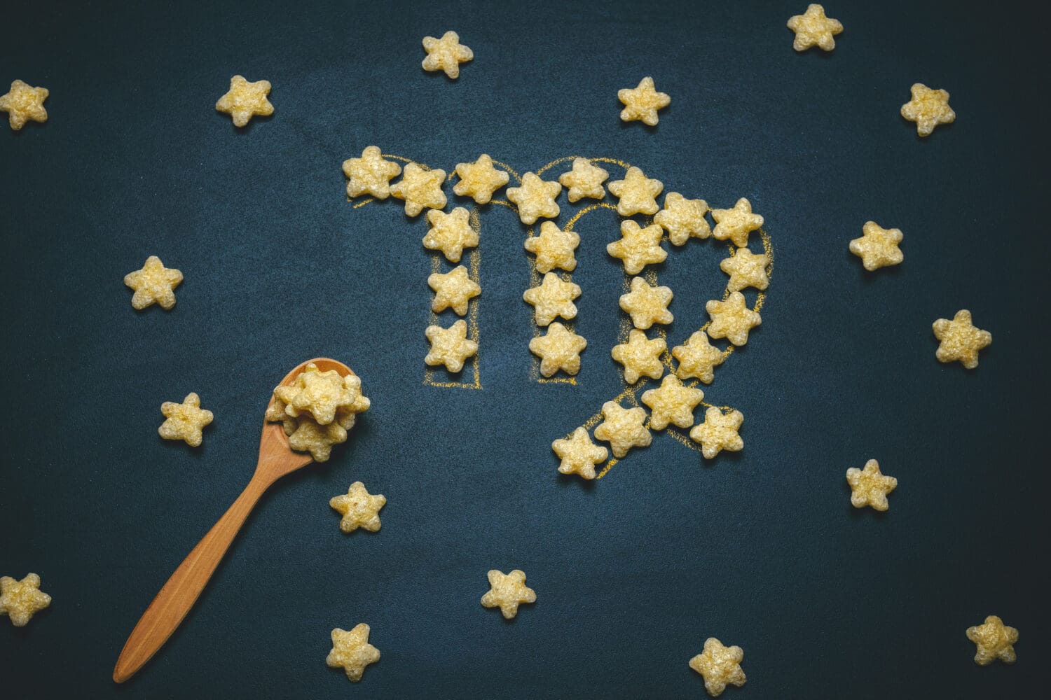 top view flat lay virgo horoscope sign made from crispy corn stars on a black background
