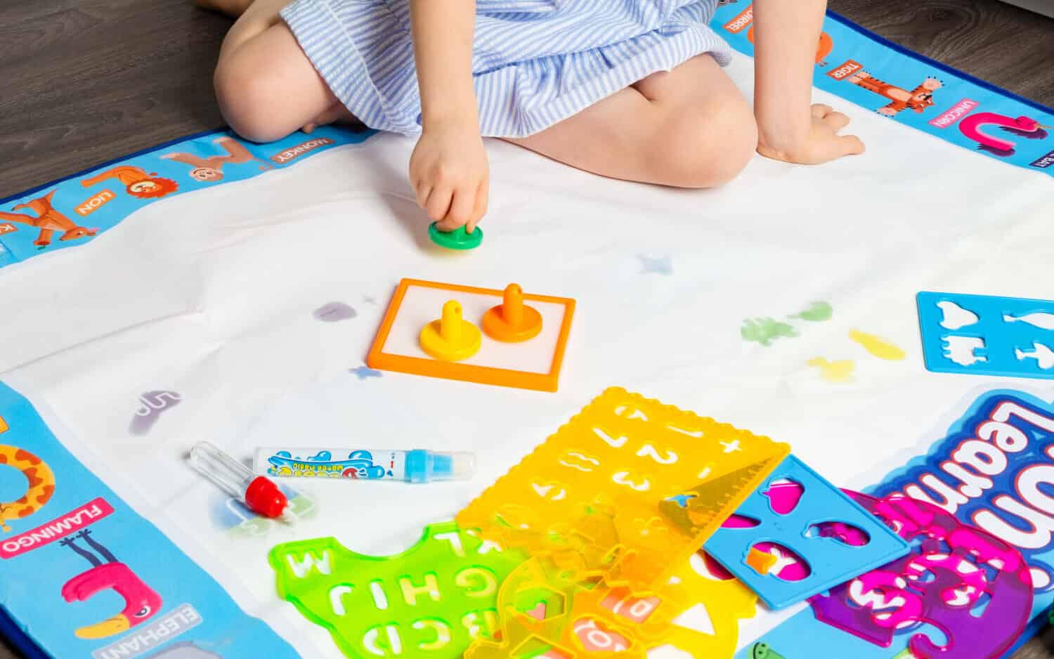 Girl 4 years old drawing on the water painting mat with doodle pan