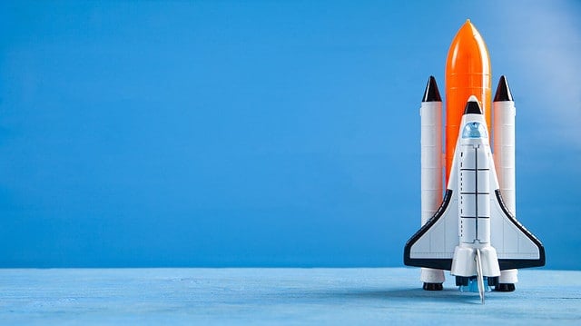 Toy space shuttle on blue background. Rocket launch