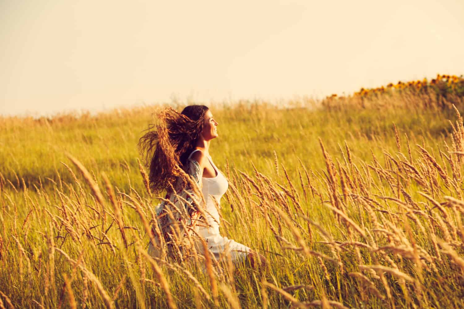 happy smiling woman wearing boho style clothes run through the grass, summer day 