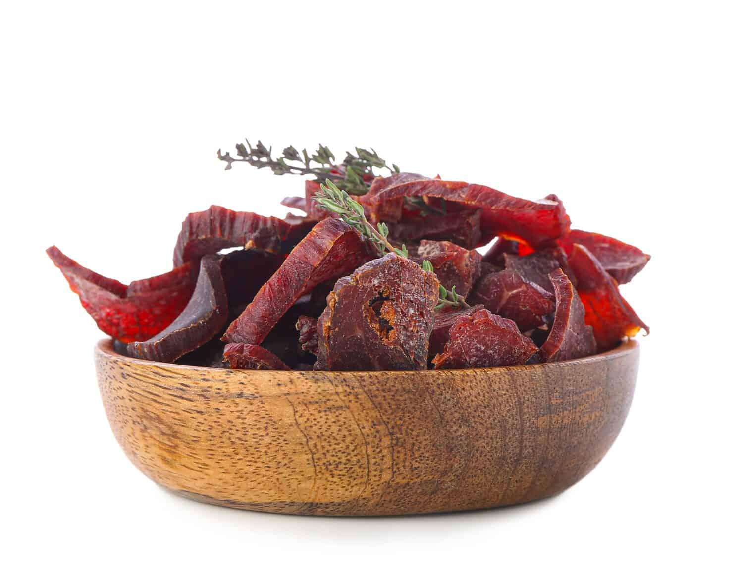 Plate with spicy beef jerky on white background